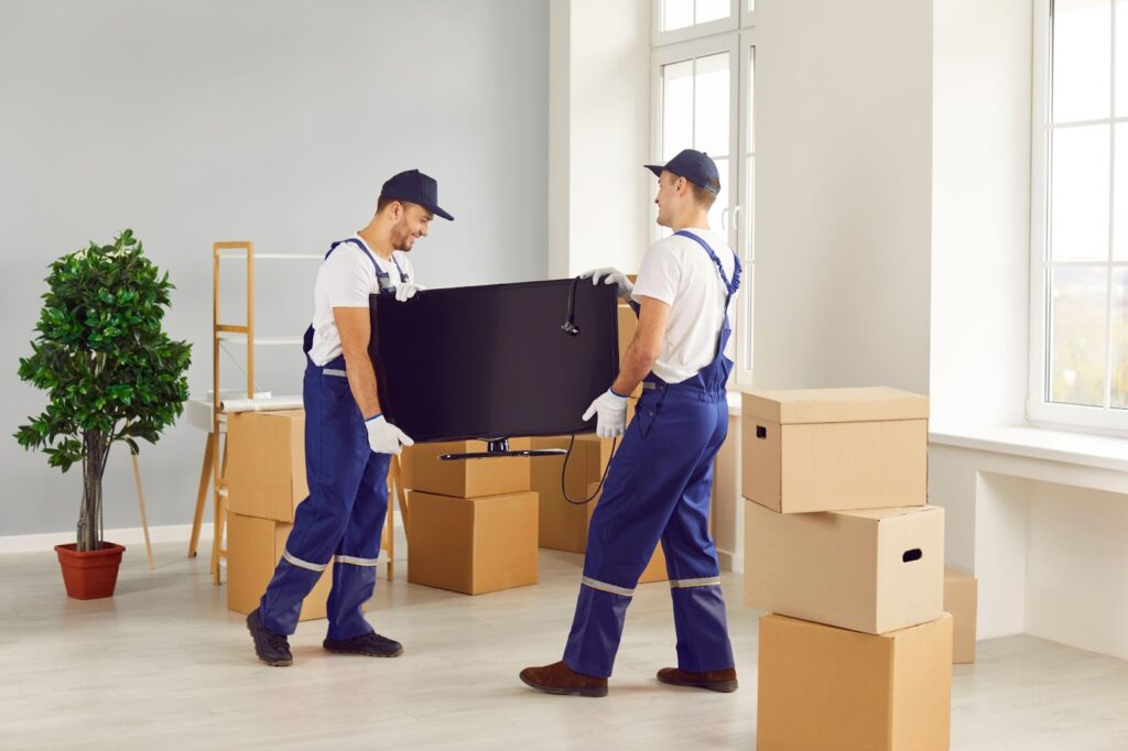 two workers lifting television